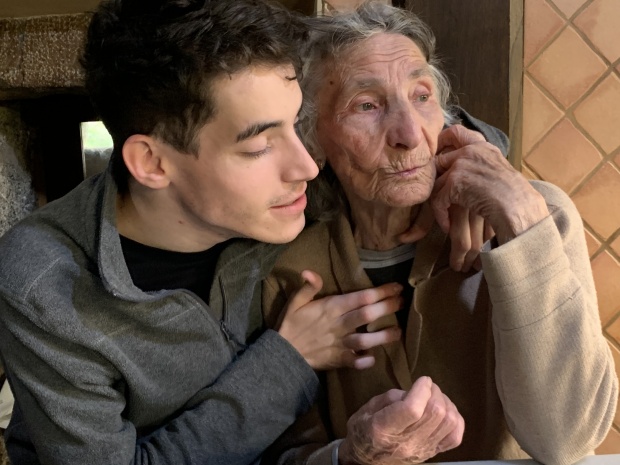 Un adolescente abrazando a su abuela.